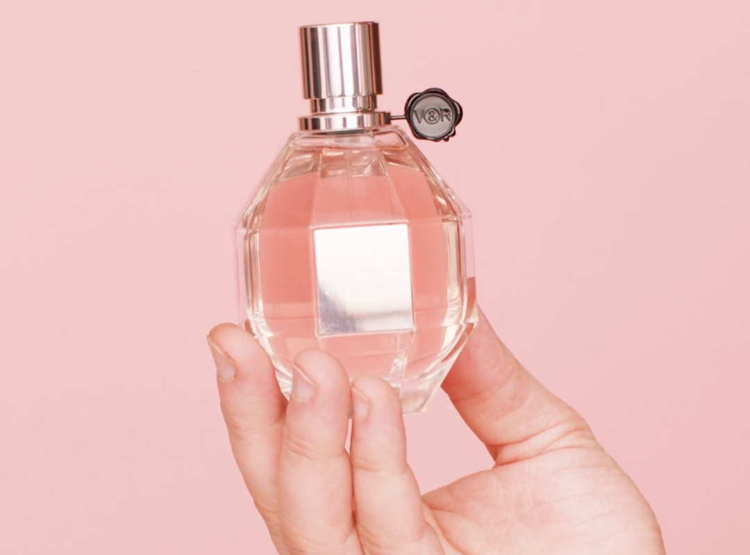 a hand holding a perfume bottle