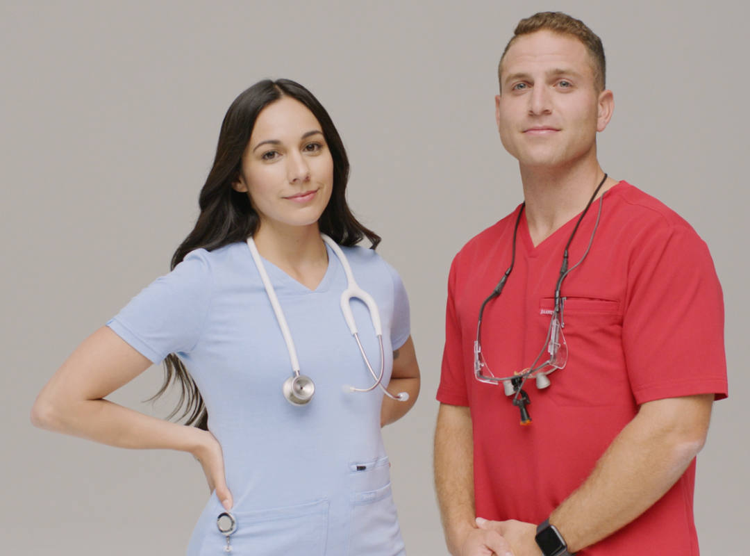 two nurses in red and blue scrubs